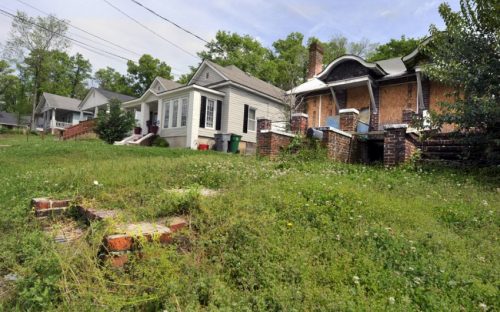 Villa Heights: Fixer-upper at rear, vacant lot in foreground.