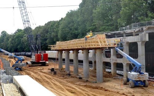 This is the Eastway Drive bridge being built over the Norfolk Southern and Blue Line Extension tracks. The work closed Eastway Drive, a major thoroughfare, in May 2014. It was to have reopened in December 2014 but now it won't open until September. In this June photo, workers install wooden forms to cap the piers before setting down the bridge deck. Photo: Nancy Pierce 