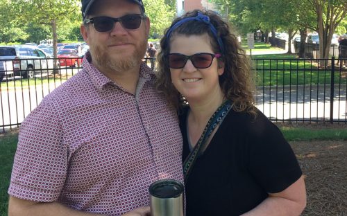 Chris and April Davis, who came along on the May 6 walking tour of NoDa, told about having their first date at the now-demolished Fat City deli. In the distance are the new condos that replaced the funky old deli. Photo: Mary Newsom