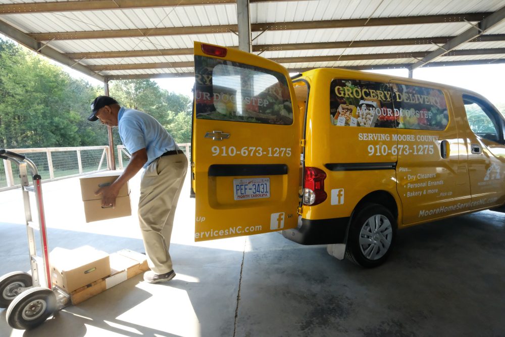 Michael Douglas of Moore Home Services packs produce boxes which he will deliver to people's homes for Sandhills Farm-to-Table, subscription-based community supported agriculture and online food store that rents space at Sandhills AGInnovation Center. Photo: Nancy Pierce