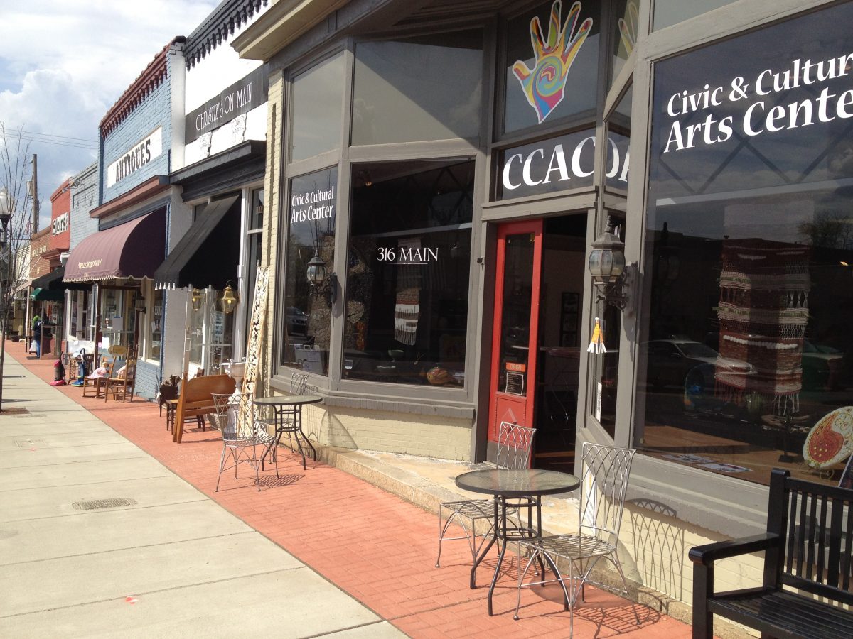 These store owners understand the importance of sittable space on the sidewalk in Pineville. Also notice the use of a pavement change to add color and mark space. 