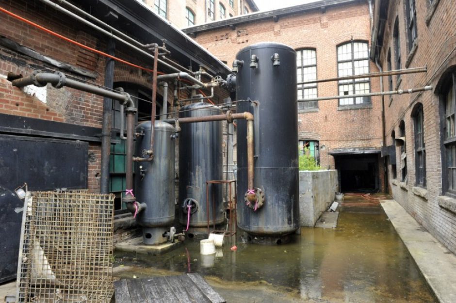 This area will be cleared for an interior courtyard with two pools and amenities. Plans call for the tanks to be incorporated into the landscape as historic interest items. Photo: Nancy Pierce